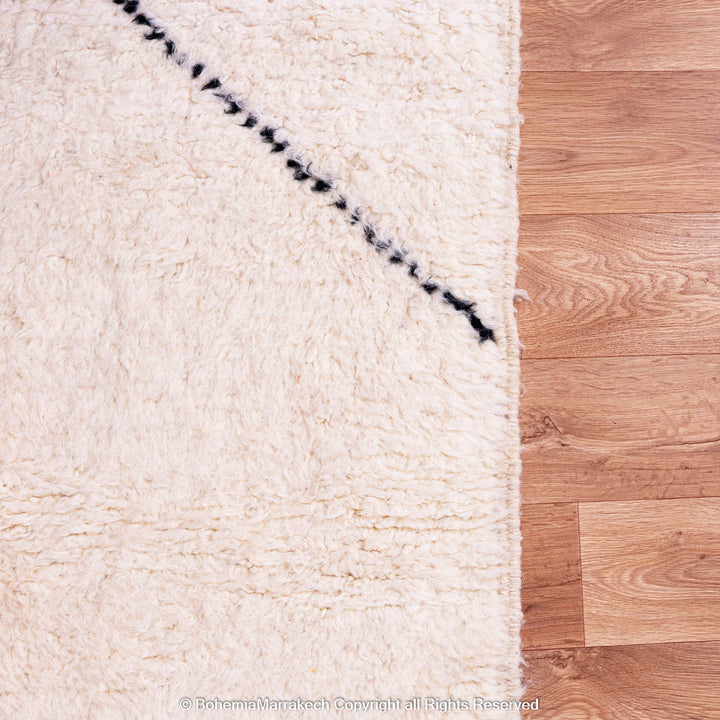 Handwoven Moroccan rug in orange, red, and white color blocks with symbolic Berber motif and soft wool texture