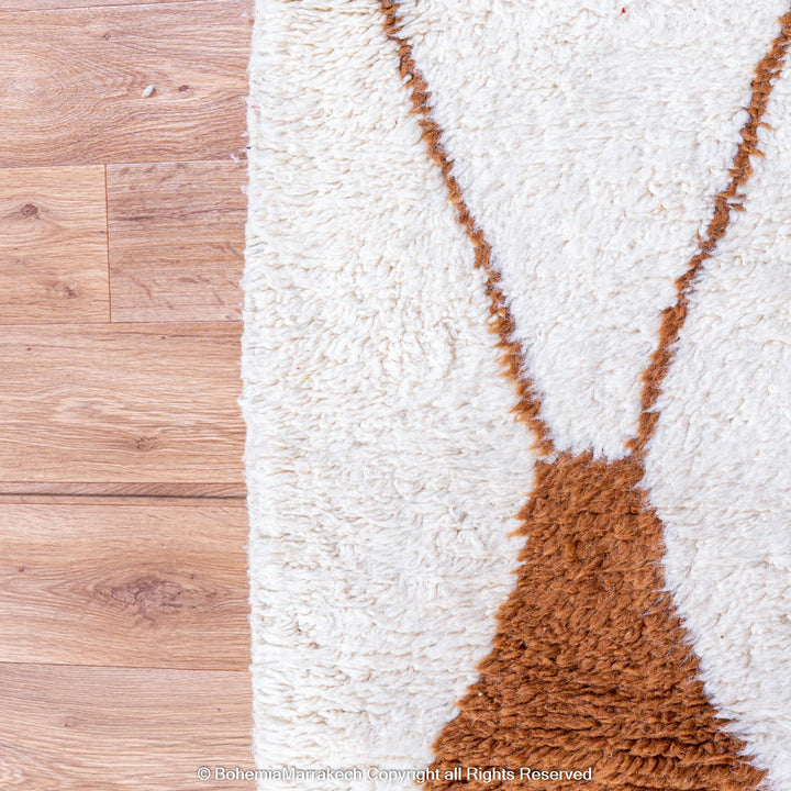 Hand-knotted Moroccan Beni Ourain wool rug with abstract brown Berber motifs on a white background