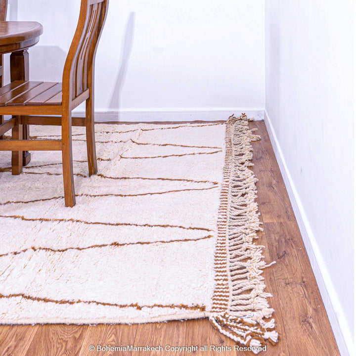 Hand-knotted Moroccan Beni Ourain wool rug with abstract brown Berber motifs on a white background