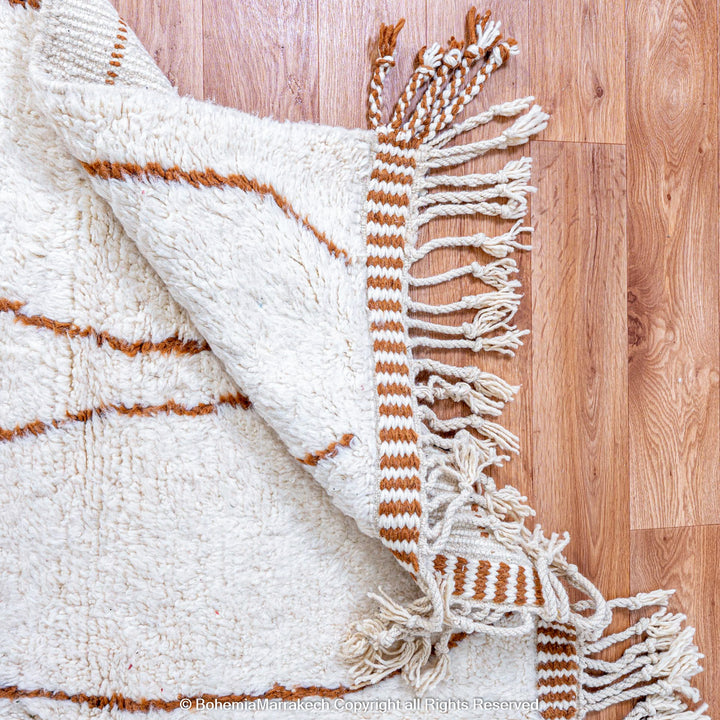 Hand-knotted Moroccan Beni Ourain wool rug with abstract brown Berber motifs on a white background