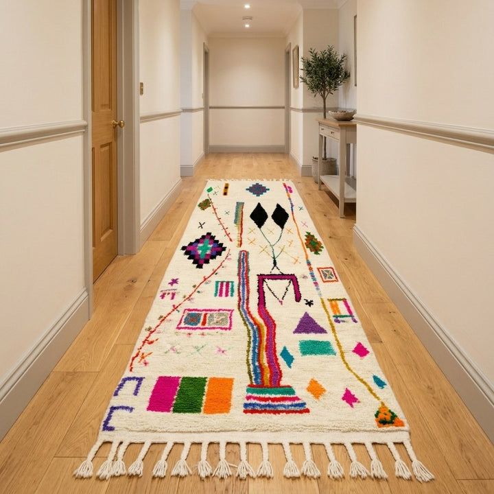 Handmade multicolor Moroccan runner rug with abstract Berber tribal symbols, colorful geometric motifs, natural wool texture, and fringe tassels.