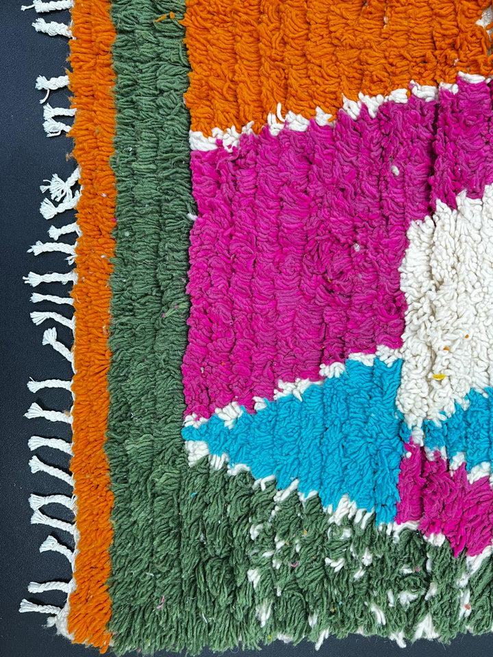 Handwoven multicolor Moroccan wool rug with orange, pink, green, and blue abstract geometric design