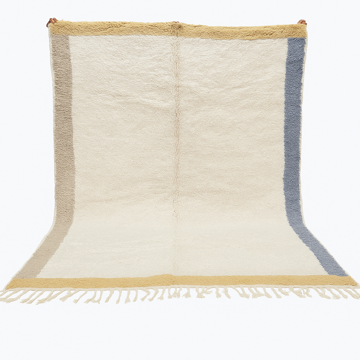 Handwoven neutral Moroccan wool rug with minimalist beige, mustard, and blue borders
