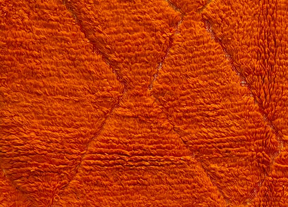 Handmade orange Moroccan runner rug with shag wool texture and diamond geometric pattern, crafted by Berber artisans.