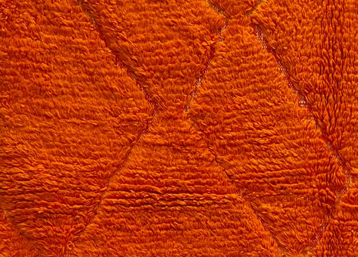 Handmade orange Moroccan runner rug with shag wool texture and diamond geometric pattern, crafted by Berber artisans.
