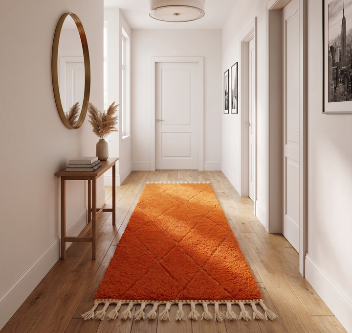 Handmade orange Moroccan runner rug with shag wool texture and diamond geometric pattern, crafted by Berber artisans.