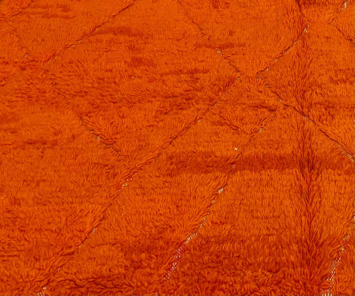 Handmade orange Moroccan runner rug with shag wool texture and diamond geometric pattern, crafted by Berber artisans.