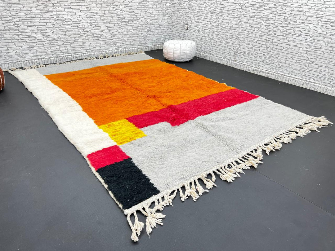 Orange Moroccan wool rug with modern color block design in red, beige, yellow, and black, handmade by Berber artisans