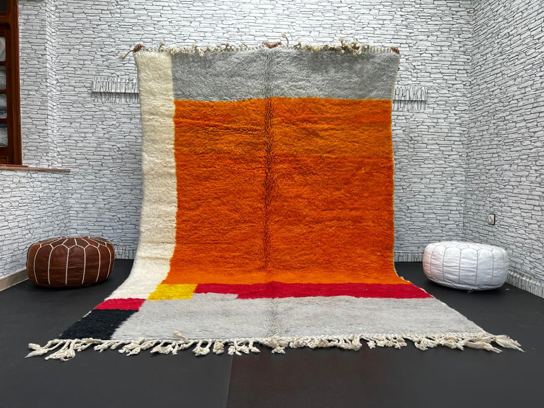 Orange Moroccan wool rug with modern color block design in red, beige, yellow, and black, handmade by Berber artisans