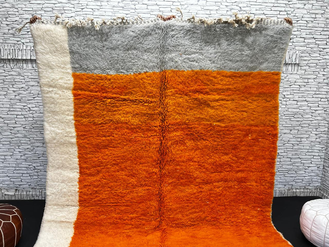 Orange Moroccan wool rug with modern color block design in red, beige, yellow, and black, handmade by Berber artisans