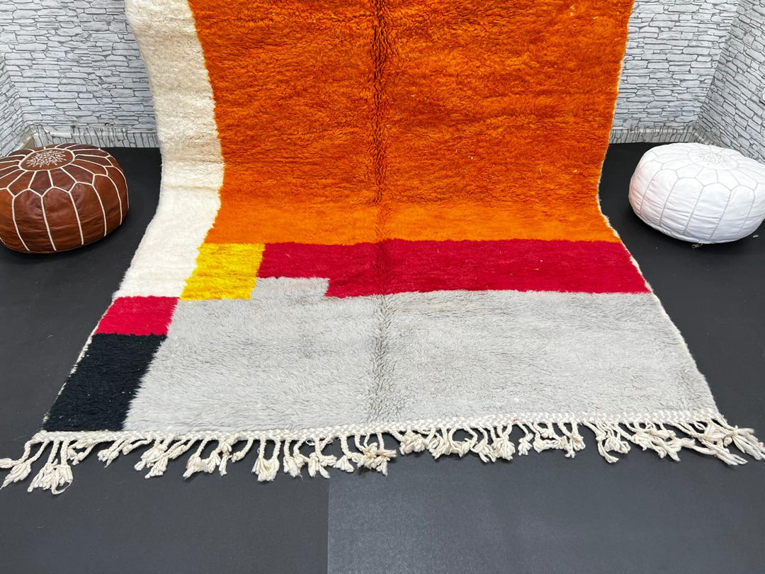 Orange Moroccan wool rug with modern color block design in red, beige, yellow, and black, handmade by Berber artisans