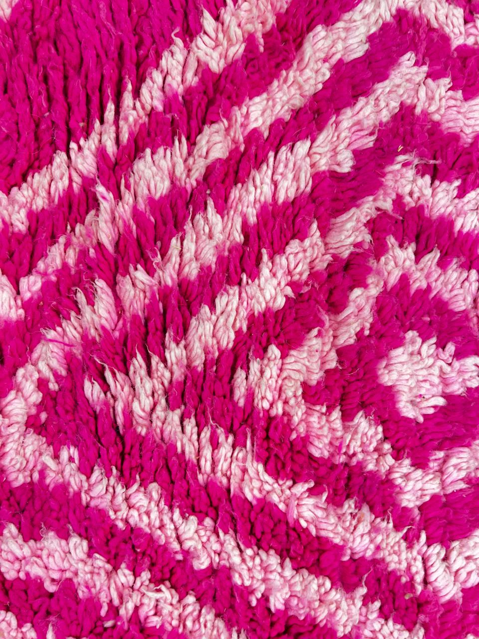 Pink Moroccan runner rug with geometric diamond pattern made of handmade wool and fringed edges on soft ivory background