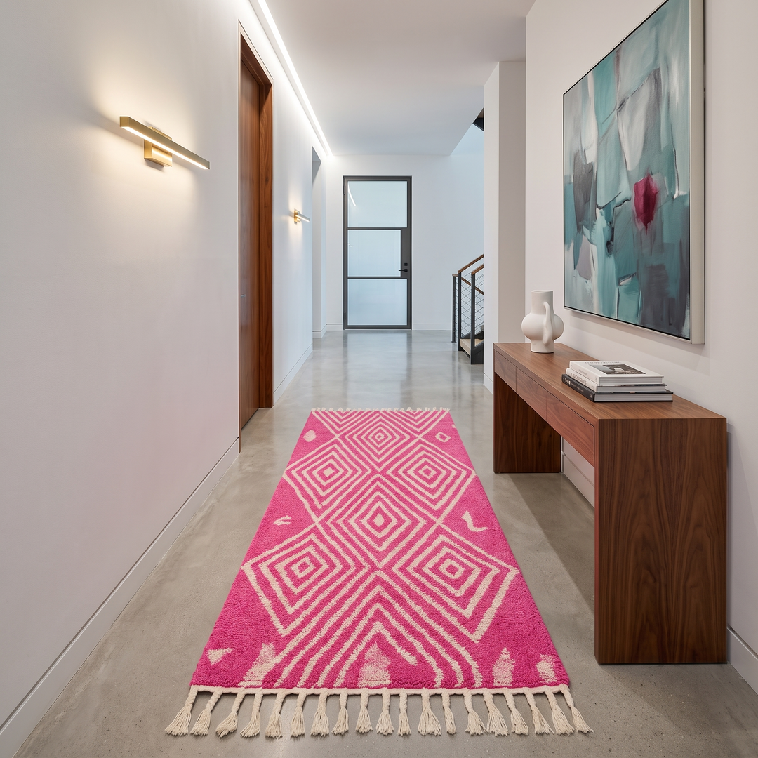 Pink Moroccan runner rug with geometric diamond pattern made of handmade wool and fringed edges on soft ivory background