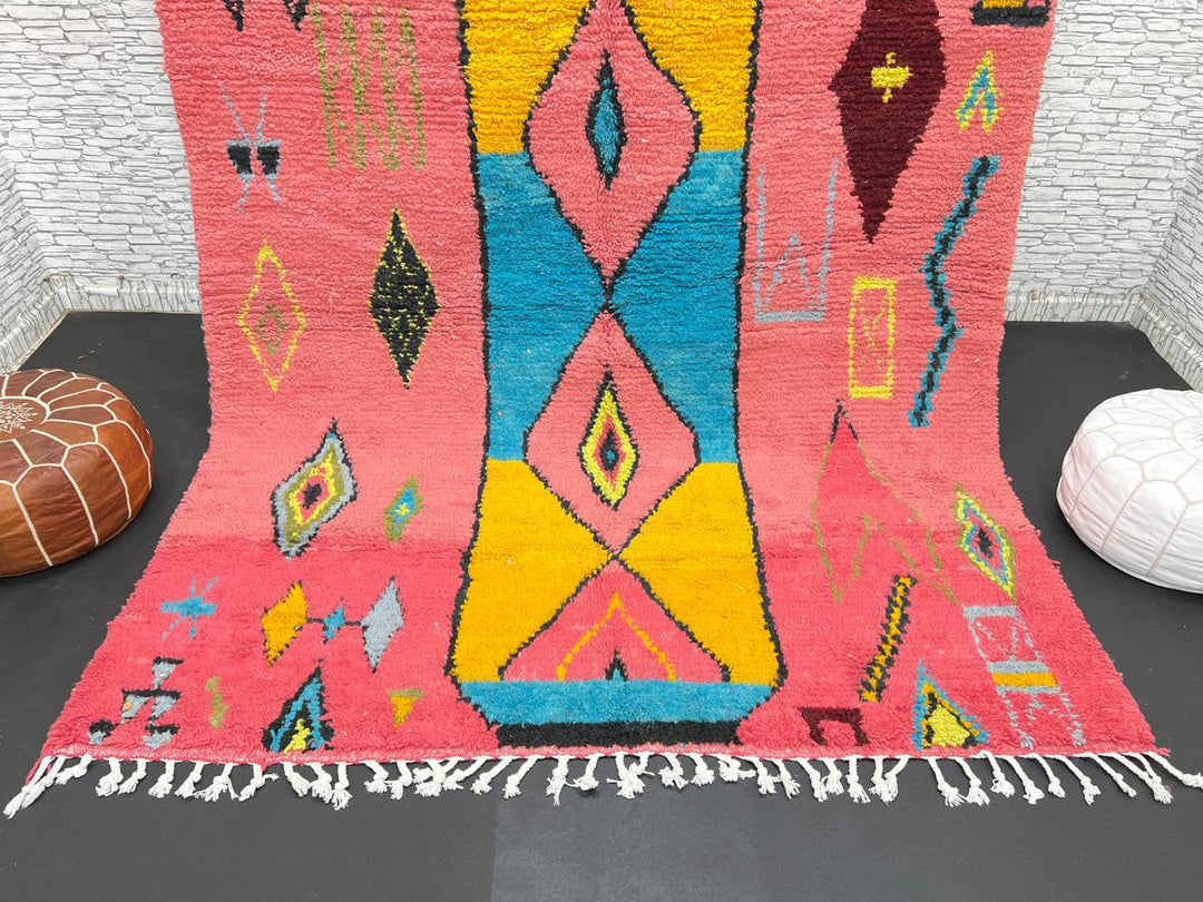 Handwoven pink Moroccan wool rug with colorful abstract geometric Berber design
