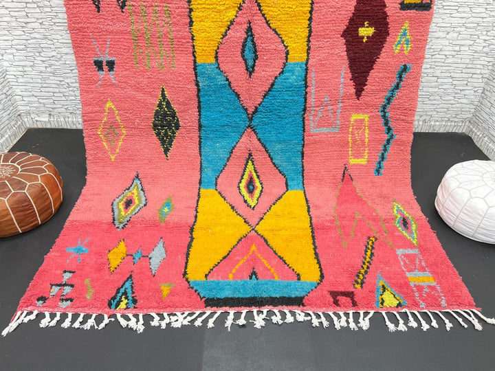 Handwoven pink Moroccan wool rug with colorful abstract geometric Berber design