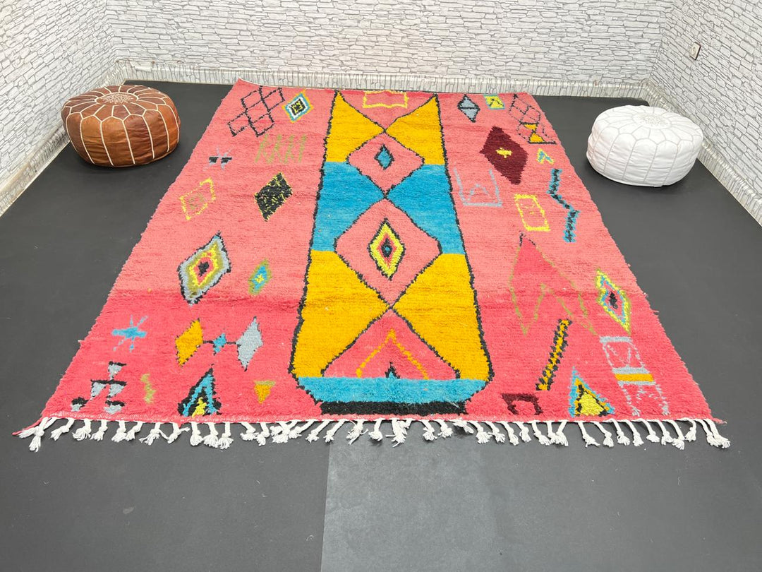 Handwoven pink Moroccan wool rug with colorful abstract geometric Berber design