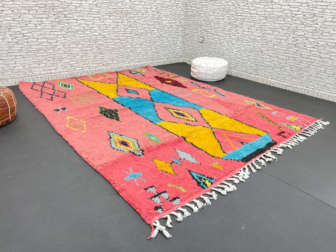 Handwoven pink Moroccan wool rug with colorful abstract geometric Berber design