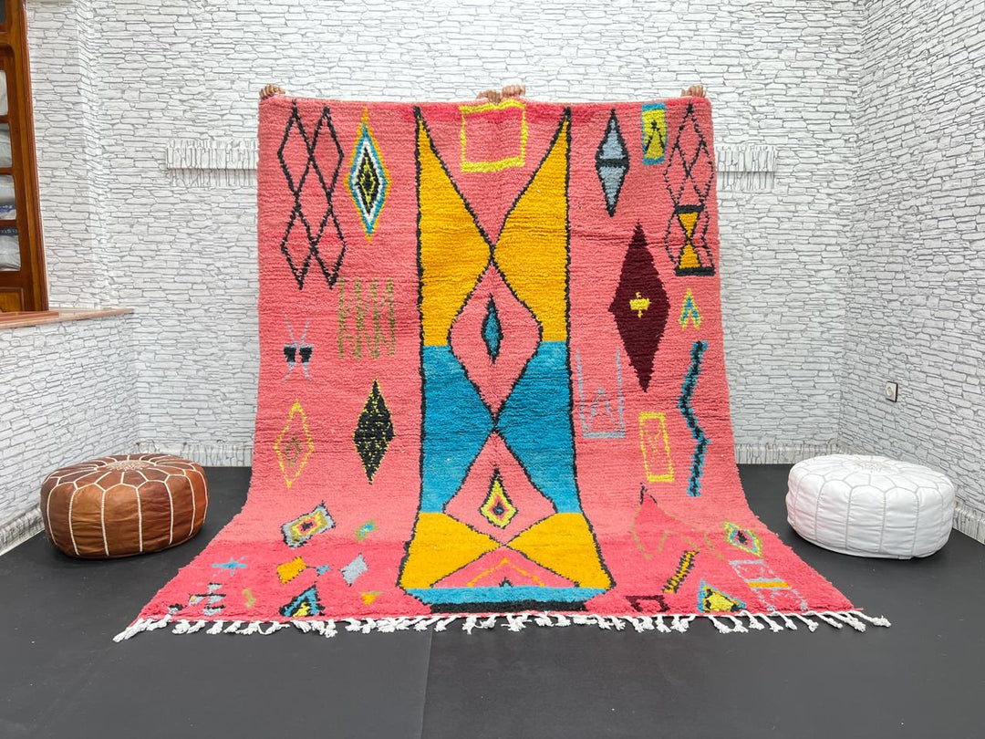 Handwoven pink Moroccan wool rug with colorful abstract geometric Berber design