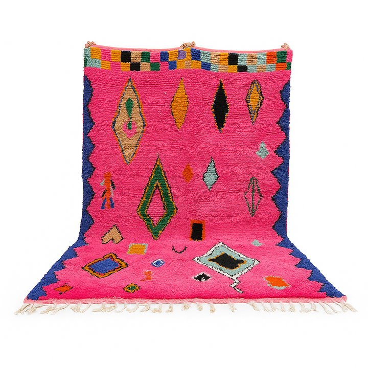 Vibrant pink Moroccan wool rug with colorful Berber motifs. 100% handmade, natural wool, and ethically crafted in Morocco.