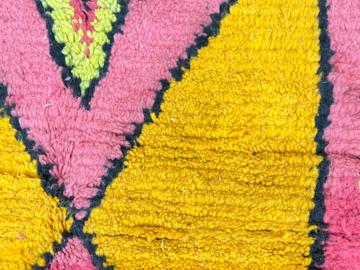 Handmade pink Moroccan wool runner rug with colorful geometric Berber motifs in yellow, turquoise, burgundy, and black