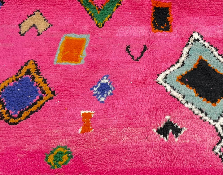 Pink handmade Moroccan round wool rug with colorful Berber tribal geometric patterns