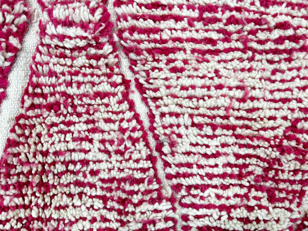 Handwoven pink Moroccan wool runner rug with white diamond lattice pattern.