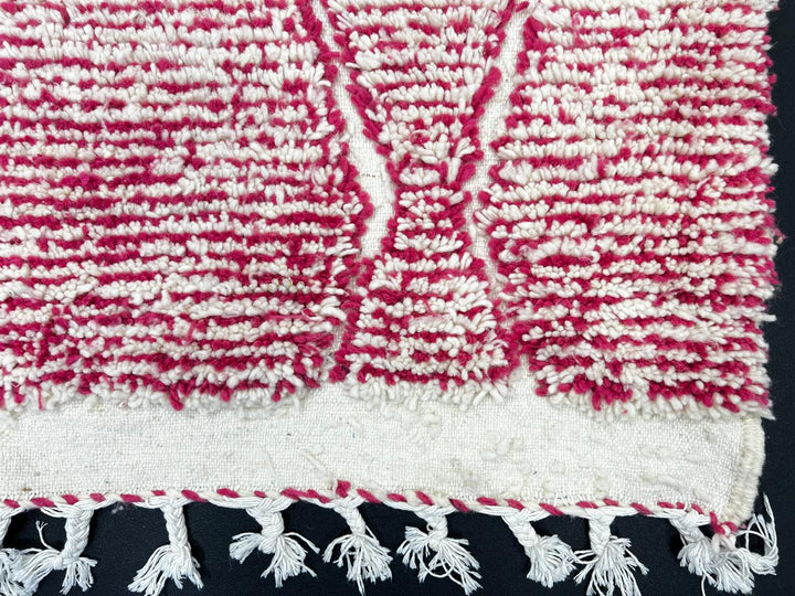 Handwoven pink Moroccan wool runner rug with white diamond lattice pattern.