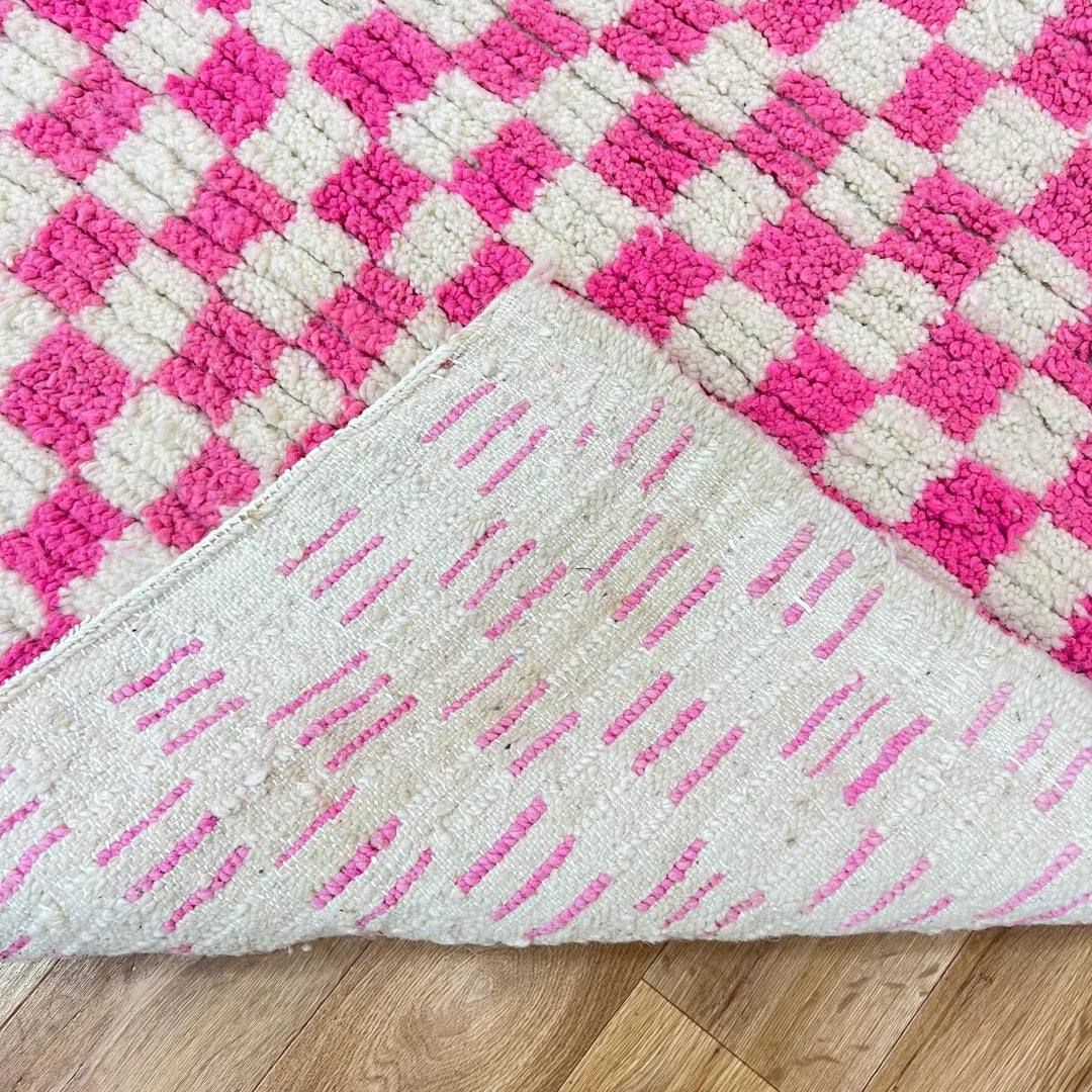 Pink and white checkered Moroccan wool runner rug with handmade Berber texture