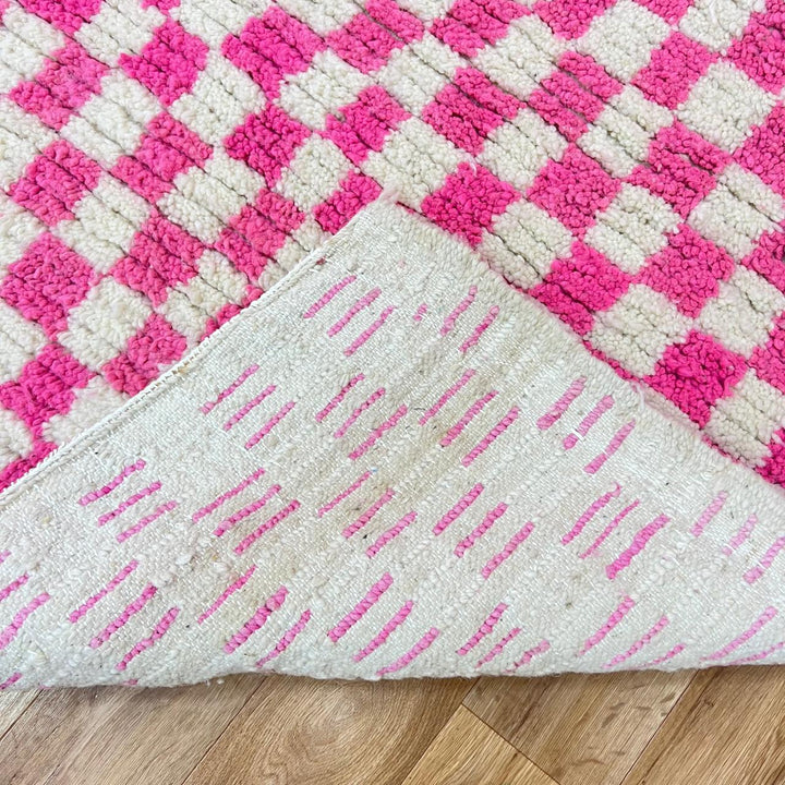Pink and white checkered Moroccan wool runner rug with handmade Berber texture