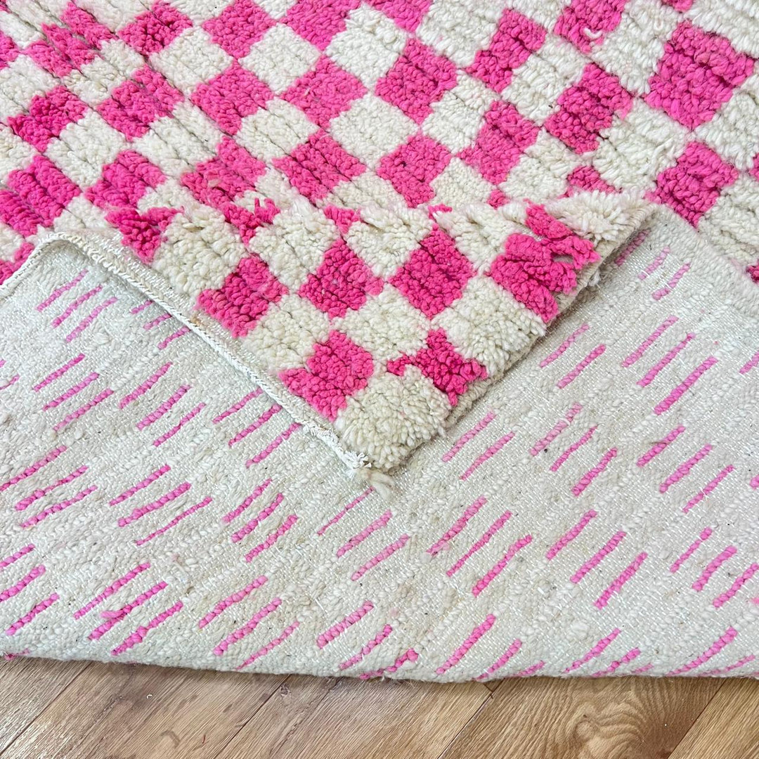 Pink and white checkered Moroccan wool runner rug with handmade Berber texture