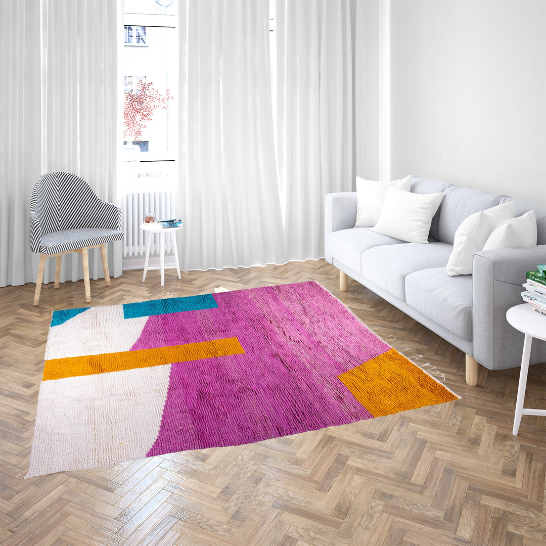 Handmade pink Moroccan wool rug with bold geometric color blocks, crafted by Berber artisans