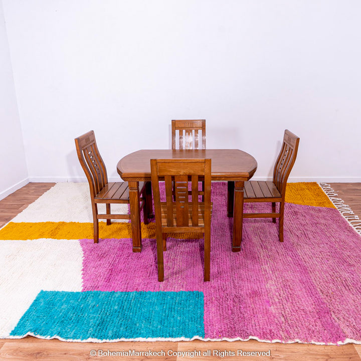 Handmade pink Moroccan wool rug with bold geometric color blocks, crafted by Berber artisans