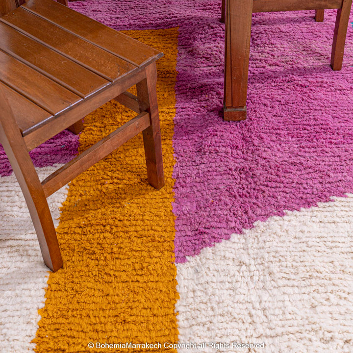 Handmade pink Moroccan wool rug with bold geometric color blocks, crafted by Berber artisans