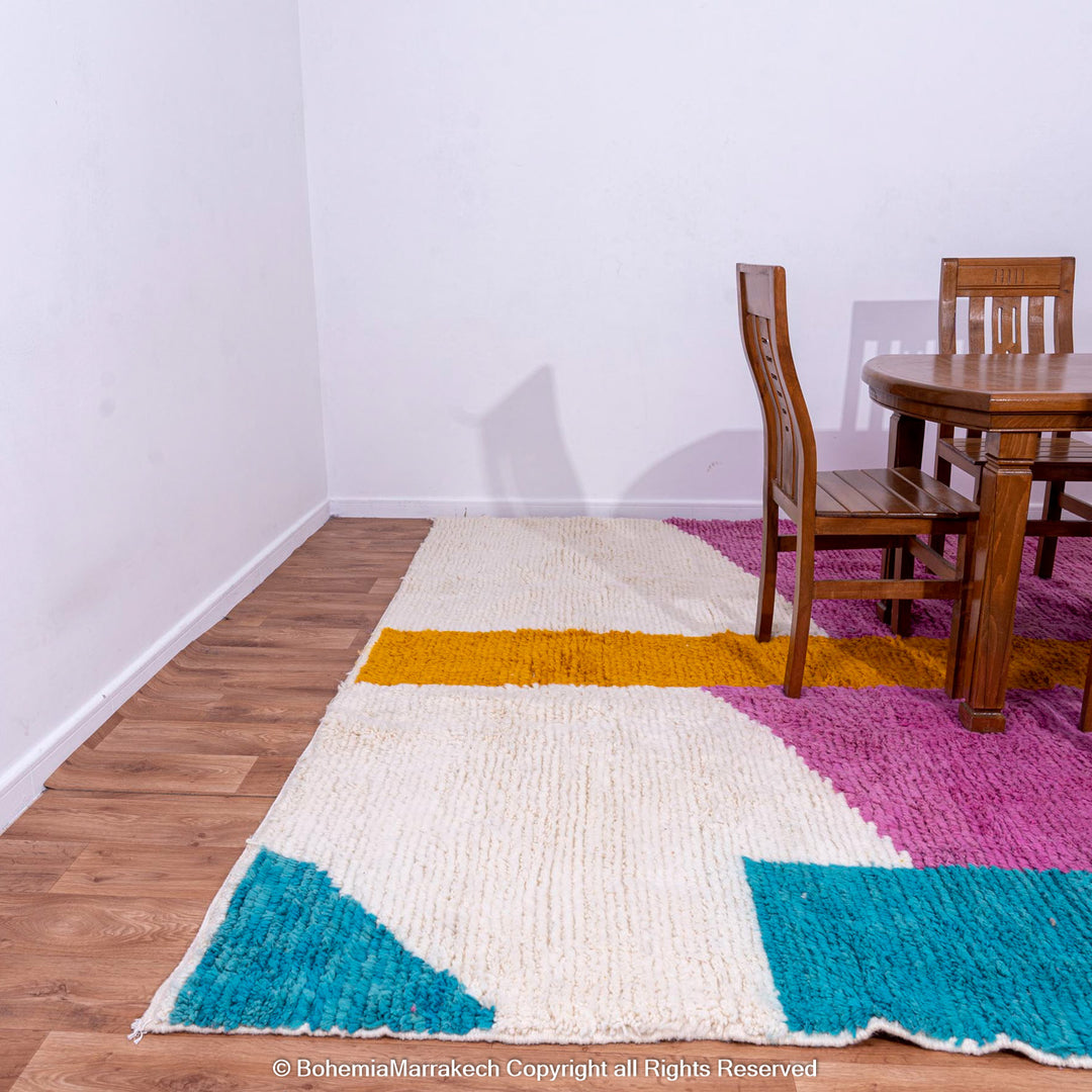 Handmade pink Moroccan wool rug with bold geometric color blocks, crafted by Berber artisans