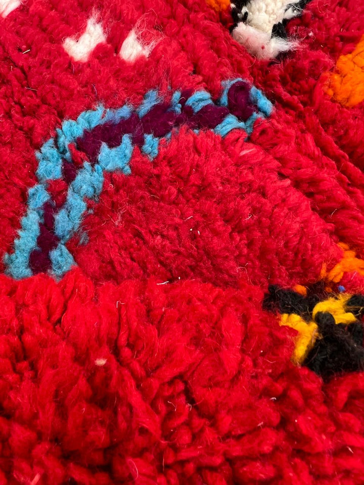 Handwoven red Moroccan wool runner rug with colorful Berber tribal patterns