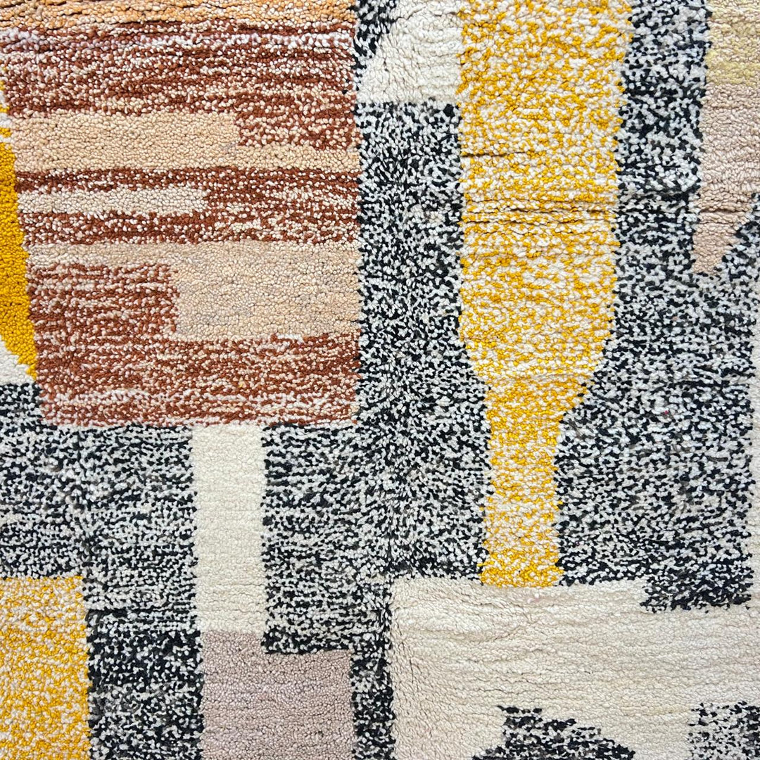 Round abstract Moroccan wool rug with geometric blocks in mustard, terracotta, ivory and charcoal on white background