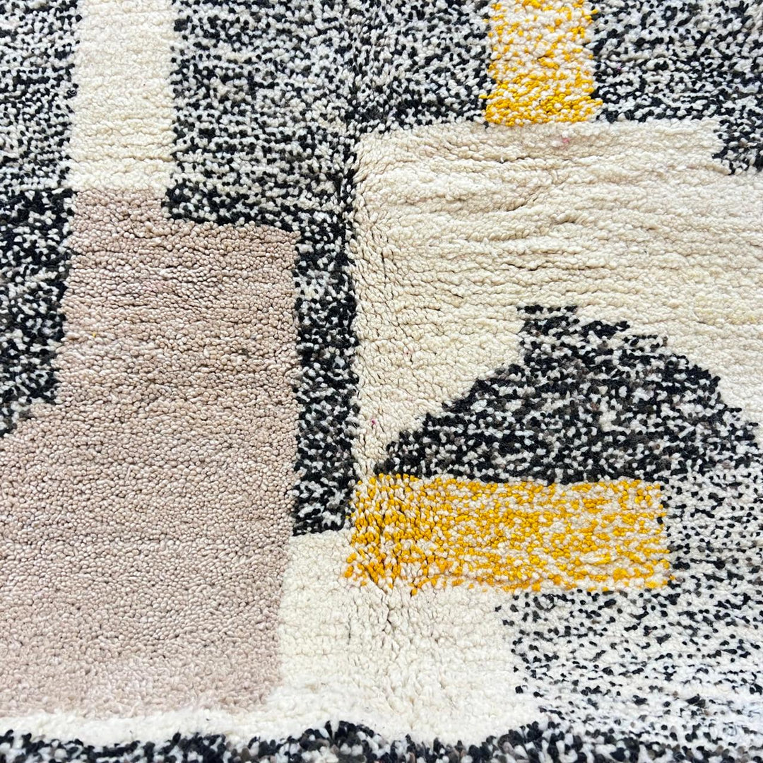 Round abstract Moroccan wool rug with geometric blocks in mustard, terracotta, ivory and charcoal on white background