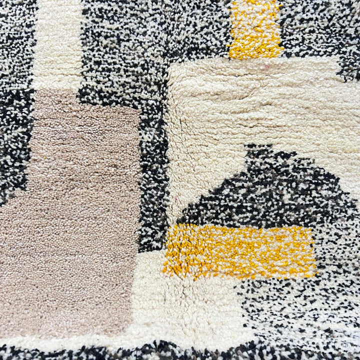 Round abstract Moroccan wool rug with geometric blocks in mustard, terracotta, ivory and charcoal on white background