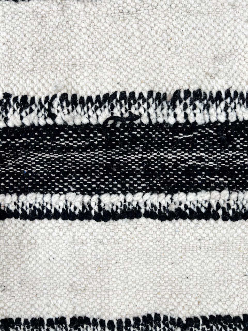 Round black and white flat-woven Moroccan rug.