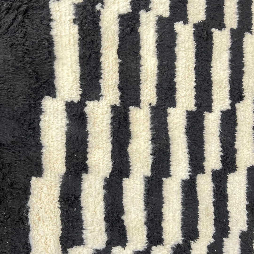Round black and white Moroccan wool rug with handmade Berber geometric pattern on a clean white background