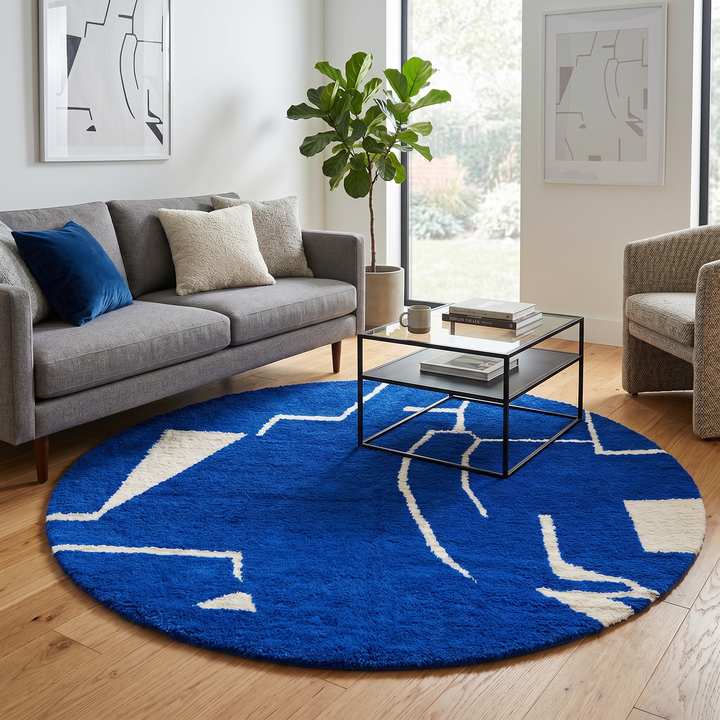 Round handmade Moroccan wool rug featuring a rich cobalt blue background with abstract ivory geometric and linear Berber-inspired patterns.