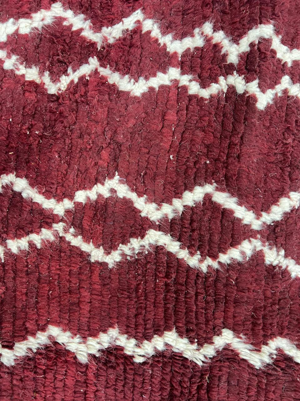 Round handmade Moroccan wool rug in burgundy with ivory zigzag Berber pattern