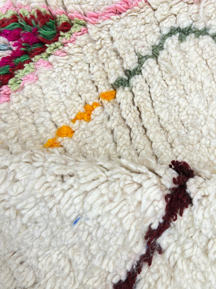 Round white Moroccan wool rug with colorful Berber diamond and arrow patterns