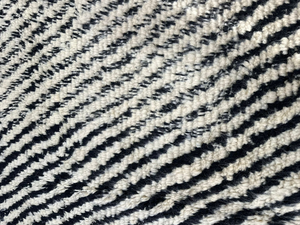 Handmade round Moroccan Berber rug in black and white with symmetrical tribal design