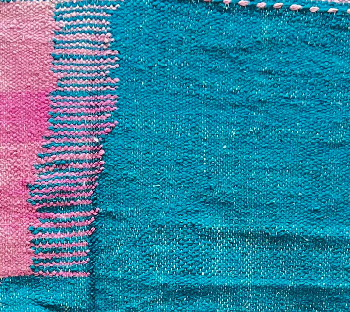 Handmade round Moroccan kilim rug with flatweave design, featuring modern pink and blue color blocks with white accents.