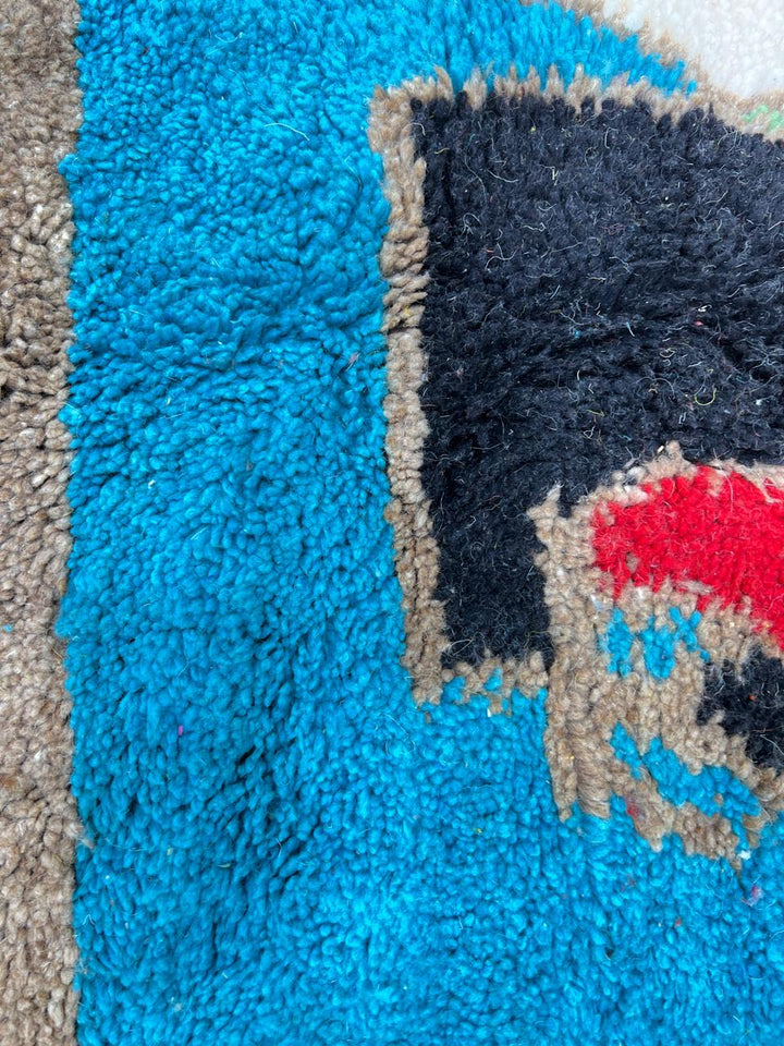 Round colorful Moroccan wool rug with abstract geometric shapes in red, yellow, blue, green, purple, and white