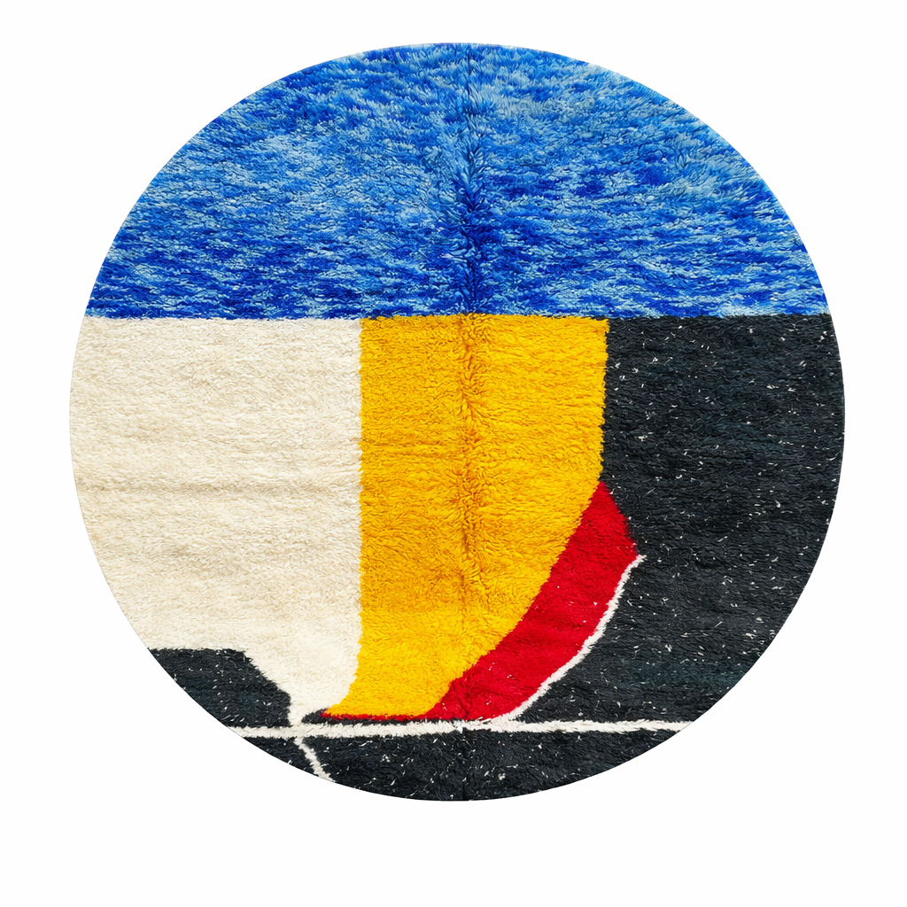 Handmade round Moroccan wool rug with abstract color-block design in blue, cream, yellow, black, and red, featuring a soft shag texture.