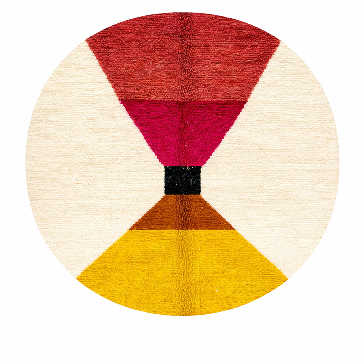 Handmade round Moroccan wool rug with bold geometric color-block design in red, magenta, brown, black, and yellow on an white base.