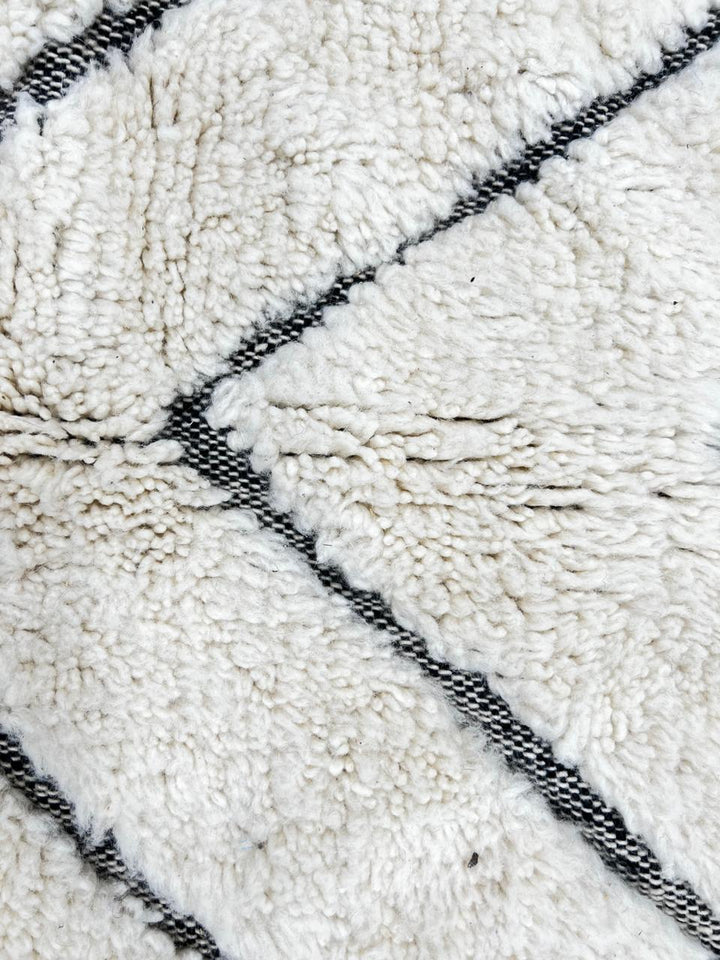 Round handmade Moroccan wool rug with modern carved line pattern, minimalist geometric design.