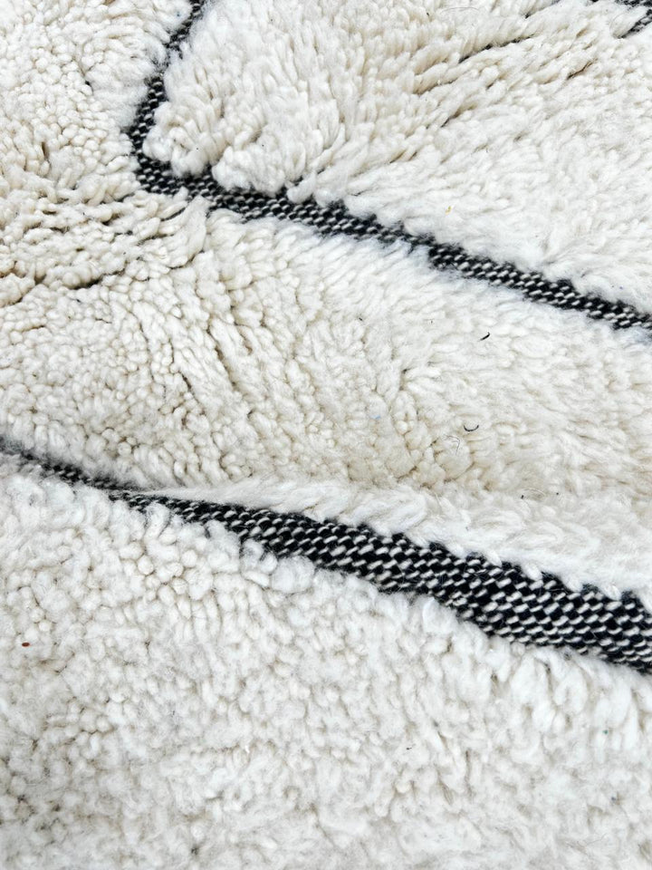 Round handmade Moroccan wool rug with modern carved line pattern, minimalist geometric design.
